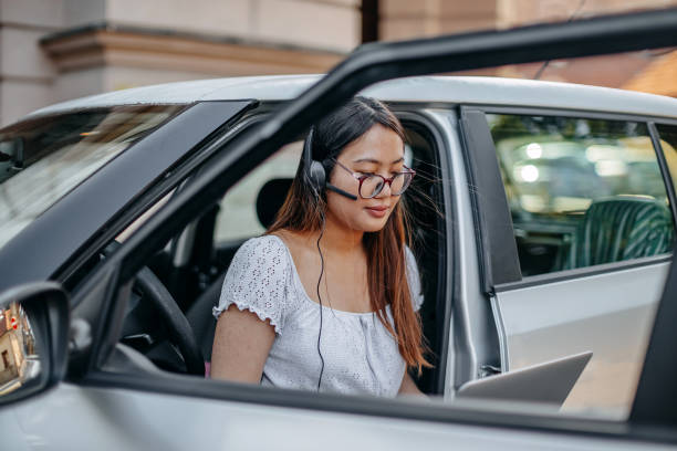 istock Young woman communicating using wireless device near vehicle 2162581472