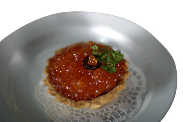 tartlet with red caviar on a white plate isolated on a white background