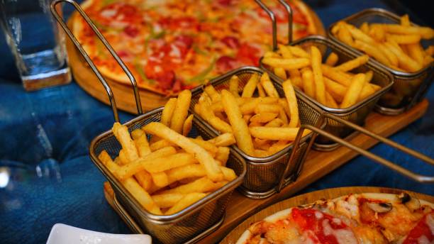 istock Crispy French Fries and Pizza on a Table 2162585319