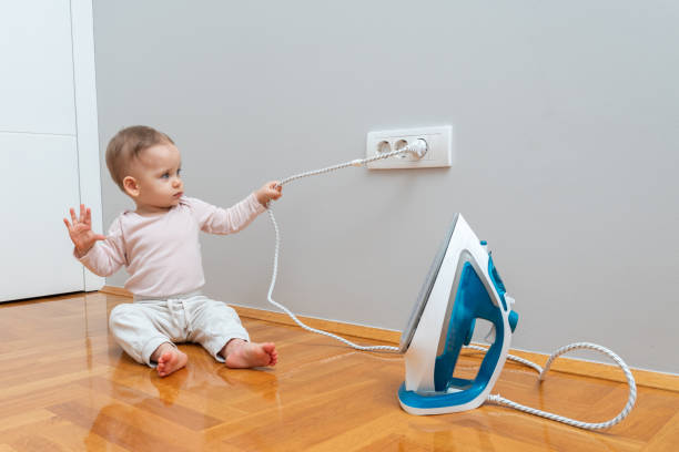 istock The child pulls the electrical plug out of the socket and turns off the iron 2162587702