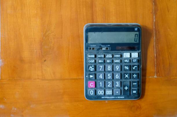 istock A black Calculator on a wooden floor background. Top view 2162592414