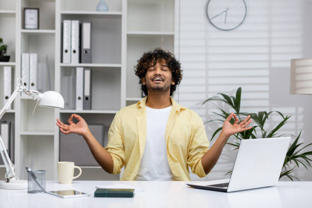 istock Man practicing mindfulness meditation at his desk in a modern office 2162594385