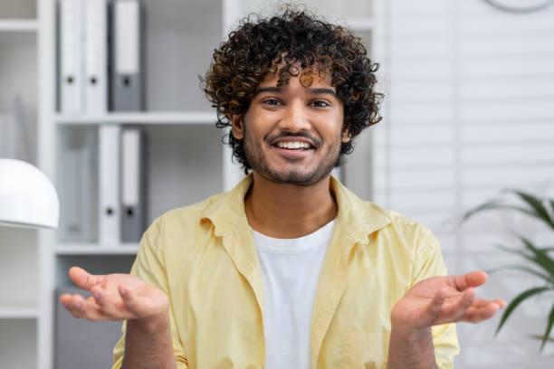 istock Smiling man looking at camera talking during video chat in office 2162594510