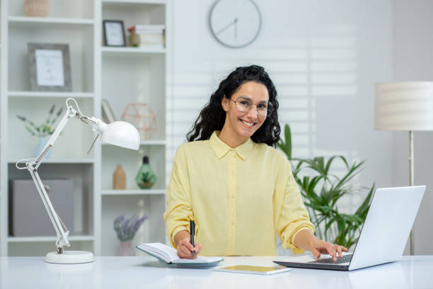 istock Female student studying at home with laptop and notebook in modern workspace 2162594553