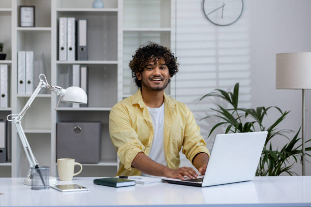 istock Happy young man working on a laptop in a modern office environment 2162595773