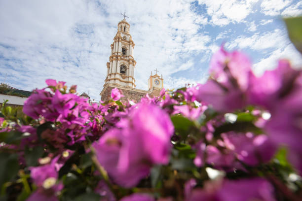 Vibrant floral cross, crafted with colorful roses, decorates a church in Quito, Ecuador, during the Holy Week celebrations, symbolizing faith and tradition