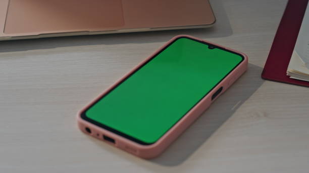 istock Green screen smartphone lying at empty workplace close up. Chroma key cellphone 2162596676