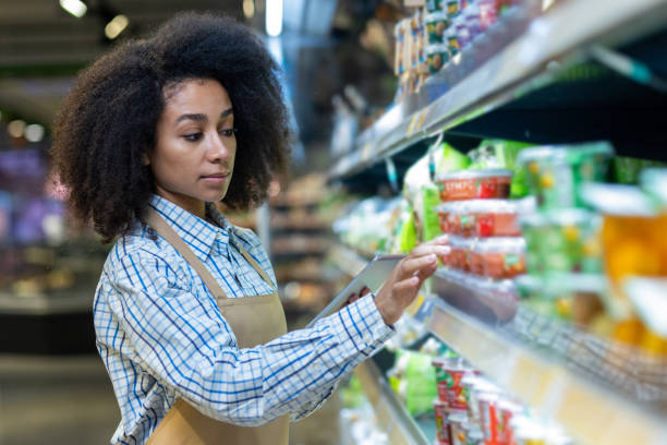 istock Young female grocery store worker using a tablet for inventory management 2162603962