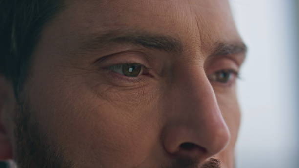 istock Frowning guy eyes watching tab looking distance home closeup. Serious man face 2162605317