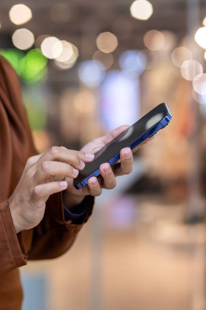 istock Close-up of hand using smartphone in modern environment with bokeh background 2162608397