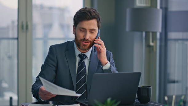 istock Smiling boss talking cellphone sitting company office closeup. Man ending call 2162609849