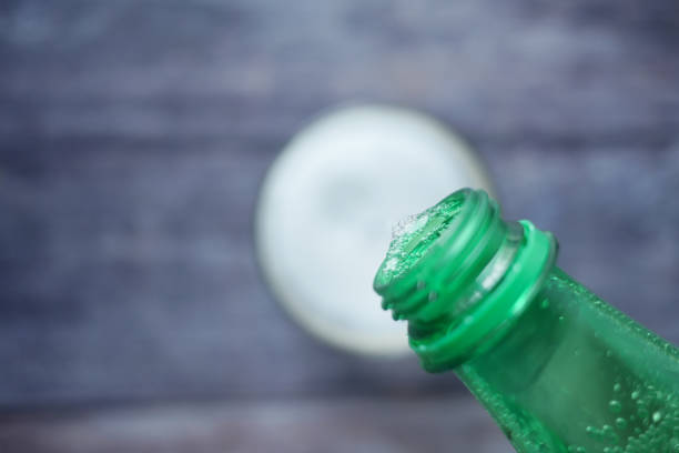 pouring soft drinks from bottle in a glass .