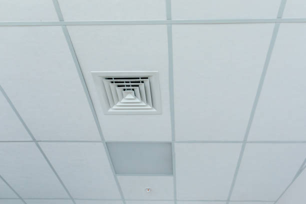 istock Suspended ceiling with square halogen spots lamps and supply and exhaust ventilation system in room in commercial room, office or warehouse. Stretch ceiling white. Stretch ceiling white. 2162617130