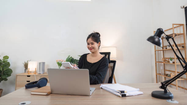 istock Young Accountant Working on Financial Documents at Home Office with Laptop and Papers, Modern Workspace, Professional and Focused 2162619434