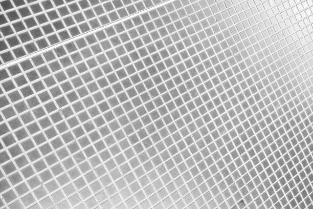 Monochrome photograph showcasing an abstract pattern of small square tiles in a linear arrangement. the geometric design and minimalistic style make it an ideal backdrop or texture for modern interior design, graphic design, or web layout projects.