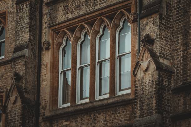 istock A brick building in Cambridge, UK with an ornate stone window featuring arched frames and a series of glass panes. 2162622751