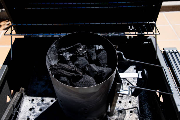 Fireplace full of charcoal to prepare barbecue. It is on top of the barbecue waiting to light the fire, just below the charcoal. It's a sunny day and outside