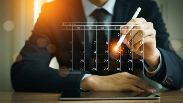istock Businessman manages time for effective work. Time management concept. Calendar on the virtual screen interface. Highlight appointment reminders and meeting agenda on the calendar. 2162623762