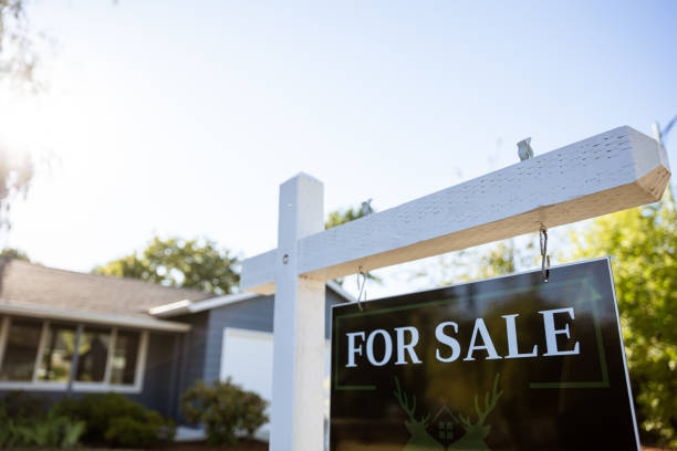 Portland Oregon House for Sale Sign in Front Yard. No people Image of a real estate for sale sign posted in front of a residential home in Portland Oregon. Shot from the street with sun as back light. house for sale sign stock pictures, royalty-free photos & images