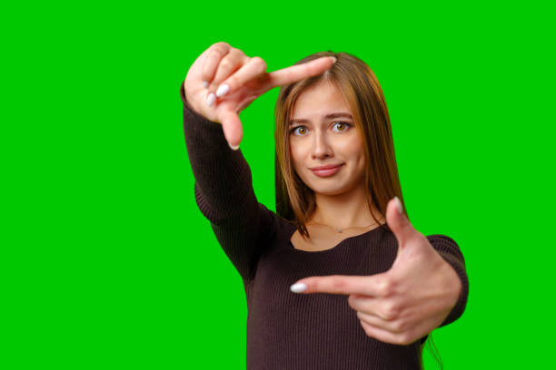 istock Woman Framing With Fingers On Green Screen 2162624499