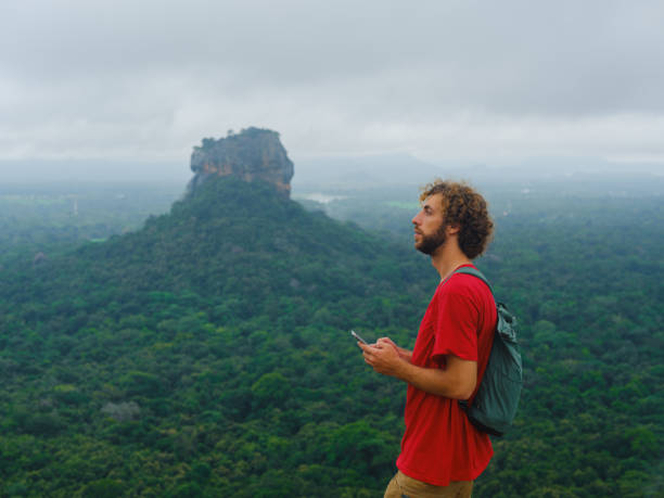 istock Man using smartphone looking at Sigiria rock in Sri Lanka 2162624527