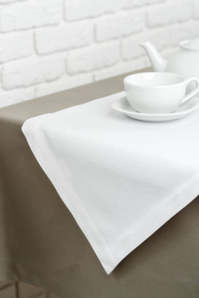 istock Beige Tablecloth on White Brick Wall With Teacups and Teapot 2162625154