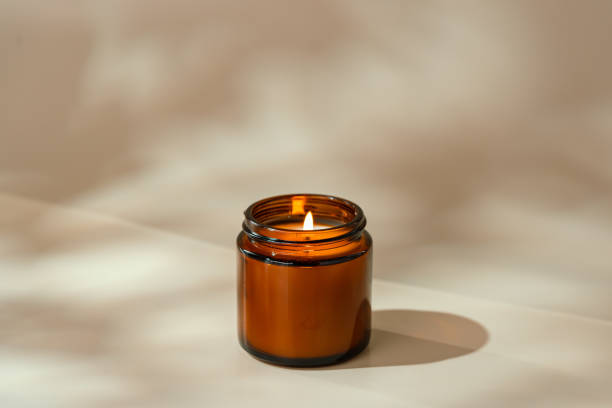 istock Candles in Glass Jars on a Light Beige Surface 2162625513