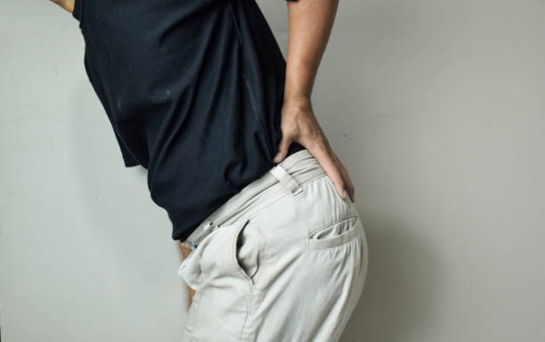 istock Man suffering from backache at front of beige background 2162625668
