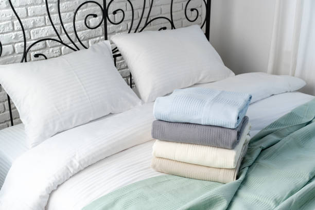 istock Stacked Blankets On A White Bed With Black Wrought Iron Headboard 2162626146