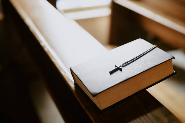 High angle view closeup of prayer book on wooden bench in Catholic church, copy space