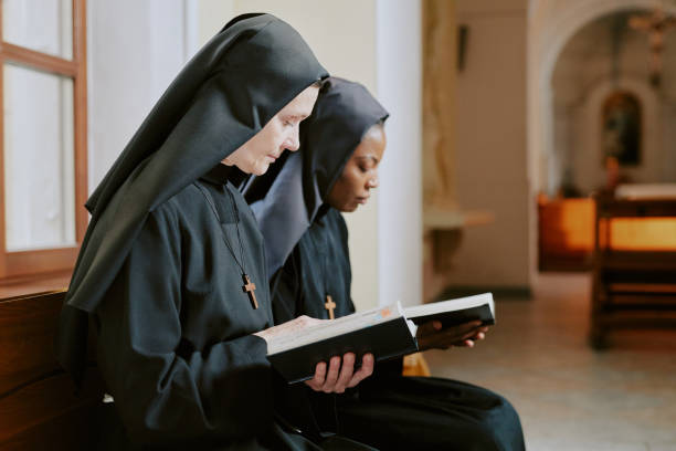 istock Two Biracial Nuns Reading Bible Texts 2162629775