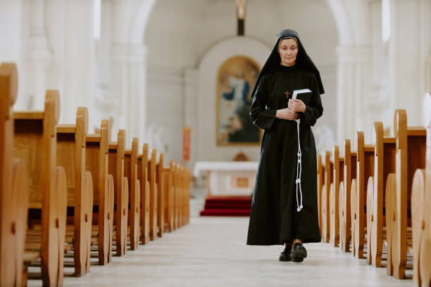 Senior Nun Walking Along Nave