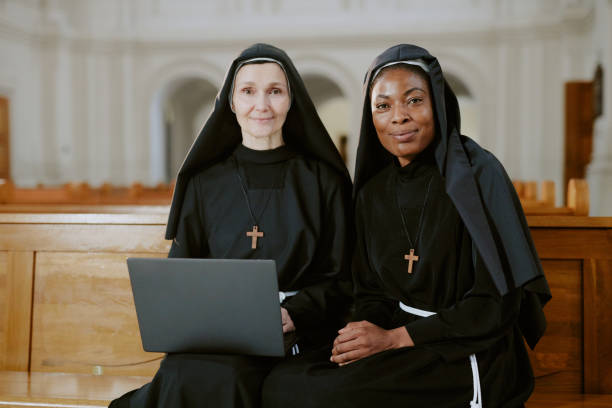 istock Two Diverse Nuns With Laptop 2162630163