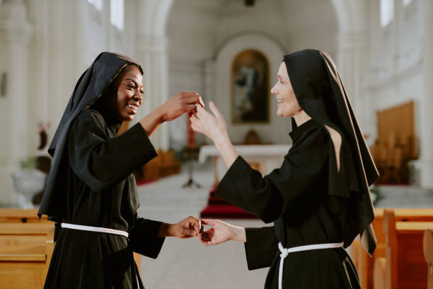 Middle age senior christian catholic nun woman over isolated background showing and pointing up with finger number one while smiling confident and happy.