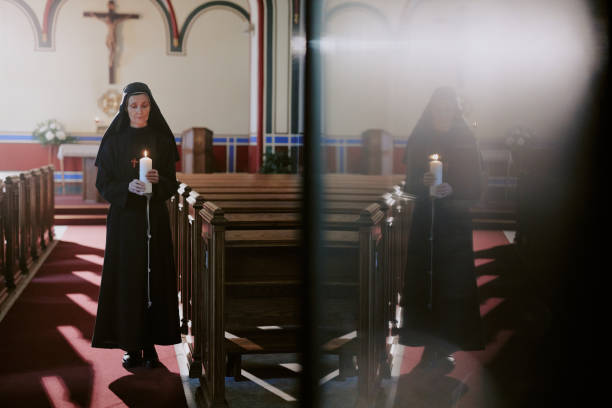 istock Senior Nun With Candle And Her Reflection 2162630466