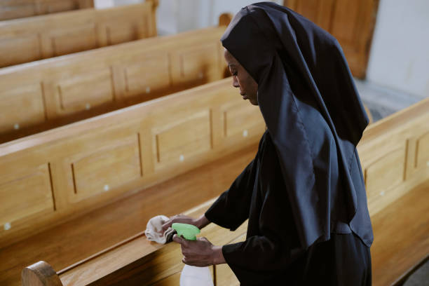 istock Young Black Nun Cleaning Pews 2162631570