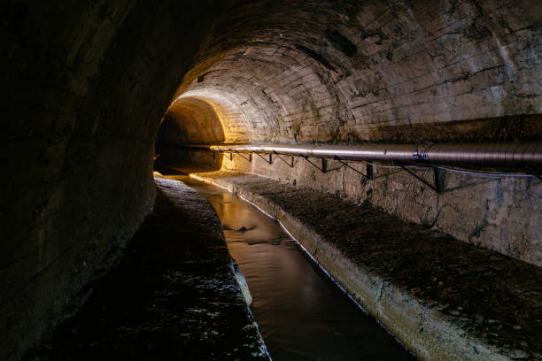 istock Underground vaulted urban sewer tunnel with dirty sewage 2162640709