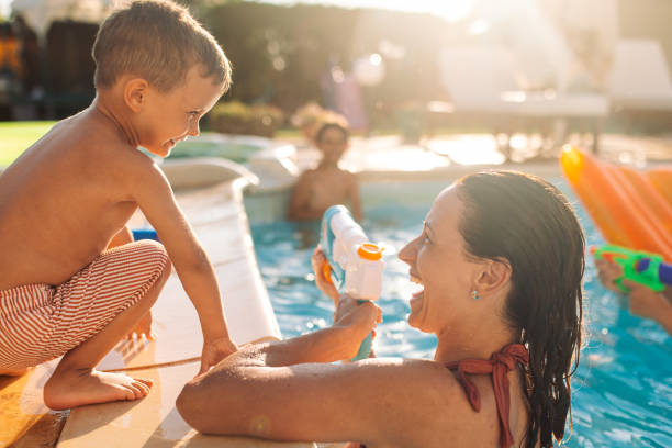 istock Child engaging in water play with his mom at the poolside. 2162641348