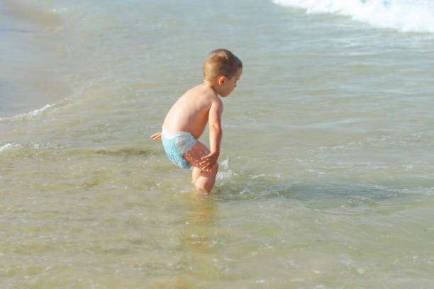 Boy playing at the beach stock photo