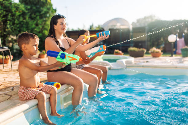 istock Kids Playing with Waterguns Poolside, Smiling and Laughing 2162643263