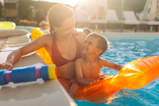 istock Mother and child enjoying pool during sunny day 2162643619