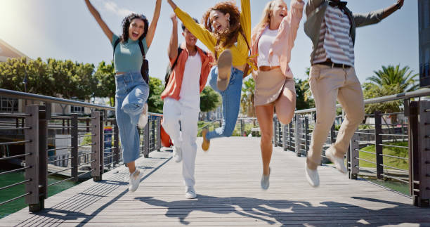 istock Group, students and people with jump at college, campus or happy for diversity, learning or development. Gen z friends. women and men in celebration, support or solidarity for education in university 2162644473