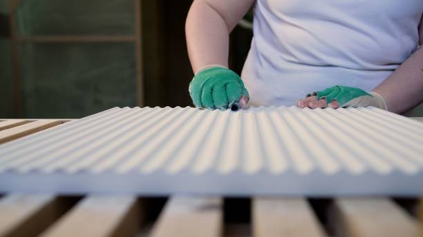 istock A female carpenter works with wood in a carpentry workshop, sanding a wooden surface with sandpaper. Hand sanding of wood panels, furniture production. 2162649207
