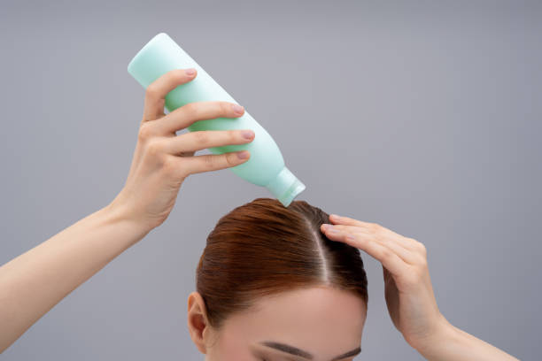 istock Young woman using a new shampoo and looking happy 2162652276