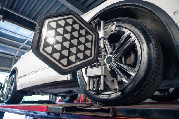 istock Car on a lift at the service station with wheel alignment equipment installed. Computerised wheel alignment machine clamp. 2162652599
