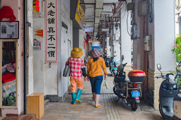 On a day in May 2024, in Qilou Old Street, Haikou City, Hainan Province, China, two female laborers were walking on the street.