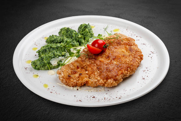 istock Chicken schnitzel served with sauce, accompanied by broccoli and cheese fritters. 2162660035