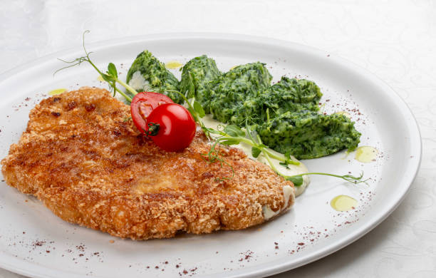 istock Chicken schnitzel served with sauce, accompanied by broccoli and cheese fritters. 2162660040