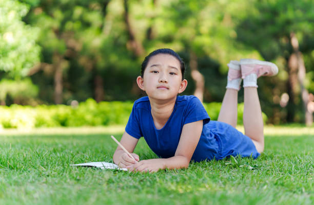 Little Girl Writing on Lawn