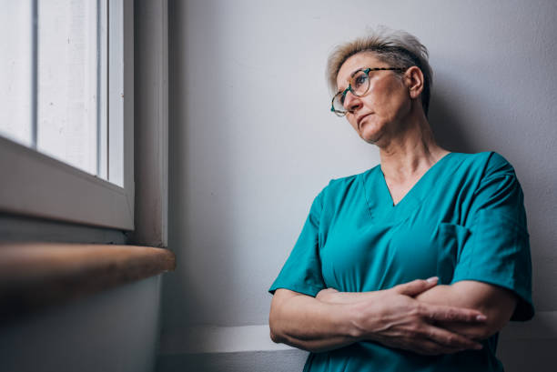 istock Nurse standing by the window in a contemplative mood. 2162665047